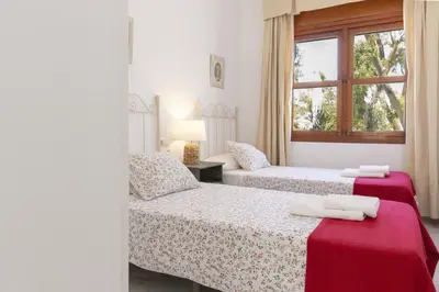 a bedroom with two beds and a window at Luminoso y amplio piso en Chipiona. 5. in Chipiona
