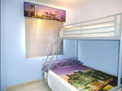 a bedroom with a bunk bed and a window at CHIPIONA SOL Y PLAYA in Chipiona