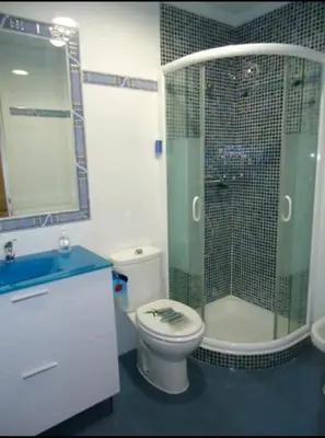a bathroom with a toilet and a glass shower at CHIPIONA SOL Y PLAYA in Chipiona