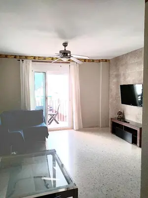 a living room with a ceiling fan and a television at CHIPIONA SOL Y PLAYA in Chipiona