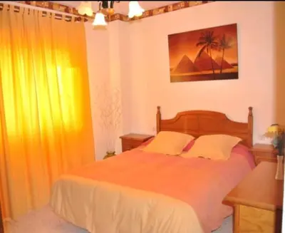 a bedroom with a large bed and a desk at CHIPIONA SOL Y PLAYA in Chipiona