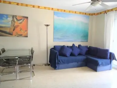 a living room with a blue couch and a table at CHIPIONA SOL Y PLAYA in Chipiona