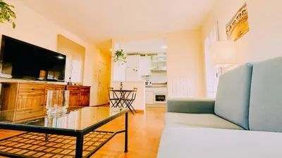 a living room with a couch and a tv at Mika's House Lite in Sanlúcar de Barrameda