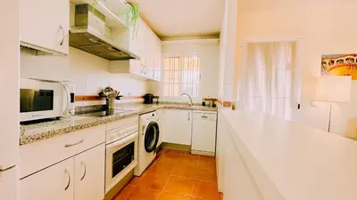 a white kitchen with a sink and a microwave at Mika's House Lite in Sanlúcar de Barrameda