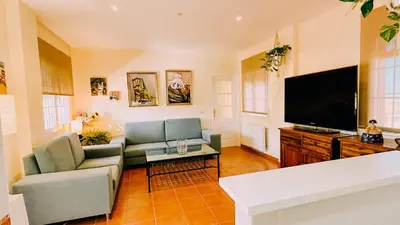 a living room with a couch and a flat screen tv at Mika's House Lite in Sanlúcar de Barrameda