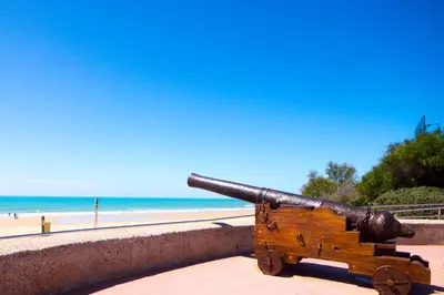 a cannon on a wall next to a beach at La Barrosa con vistas al mar in Novo Sancti Petri