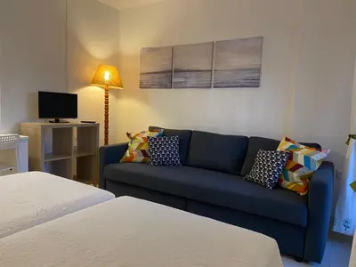 a living room with a blue couch and a tv at MyChoice Soleá in Rota
