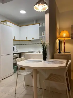 a kitchen with a table and chairs and a lamp at MyChoice Soleá in Rota