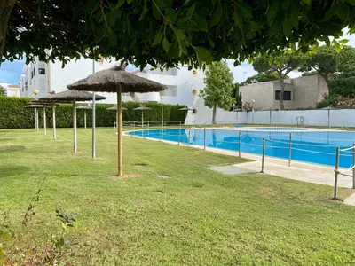 a swimming pool with umbrellas next to a swimming pool at MyChoice Soleá in Rota