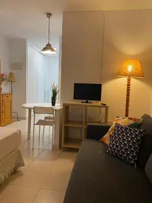 a living room with a couch and a table with a tv at MyChoice Soleá in Rota