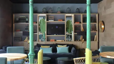 a living room with blue couches and a tv at Hotel Jerez & Spa in Jerez de la Frontera