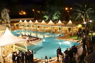 a group of people standing around a swimming pool at night at Hotel Jerez & Spa in Jerez de la Frontera