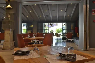 a dining room with a table and chairs and a restaurant at Hotel Jerez & Spa in Jerez de la Frontera
