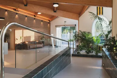 a lobby with a staircase and a couch and plants at Hotel Pradillo Conil in Conil de la Frontera