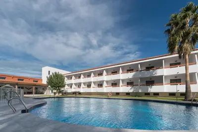 a hotel with a swimming pool in front of a building at Hotel Pradillo Conil in Conil de la Frontera