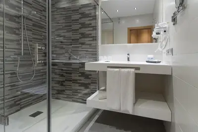 a bathroom with a glass shower and a sink at Hotel Pradillo Conil in Conil de la Frontera