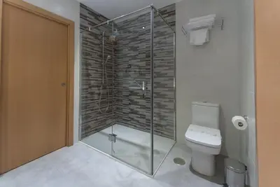 a bathroom with a glass shower with a toilet at Hotel Pradillo Conil in Conil de la Frontera