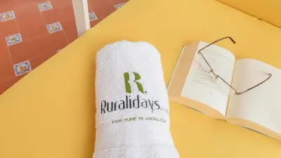 a book and a pair of glasses and a sock with the letter r on it at Apartamento Caracola Chipiona by Ruralidays in Chipiona