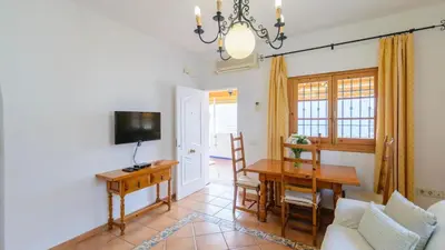 a living room with a table and a dining room at Apartamento Caracola Chipiona by Ruralidays in Chipiona