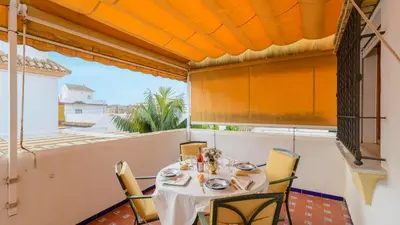 a dining room with a table and chairs on a balcony at Apartamento Caracola Chipiona by Ruralidays in Chipiona