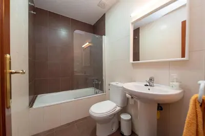 a bathroom with a toilet and a sink and a tub at Piso SieteRevueltas in Sanlúcar de Barrameda