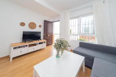 a living room with a couch and a tv at Piso SieteRevueltas in Sanlúcar de Barrameda