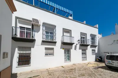 a white building with windows and balconies on it at Piso SieteRevueltas in Sanlúcar de Barrameda