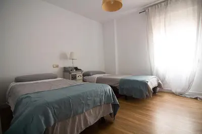 a bedroom with two beds and a window at Apartamento Albareda Centro in El Puerto de Santa María