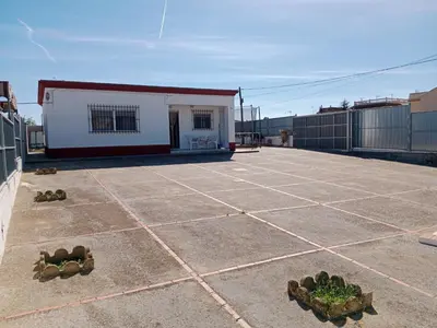 a patio with a small white building in the background at La Casa de la Abuela Jesús in Sanlúcar de Barrameda