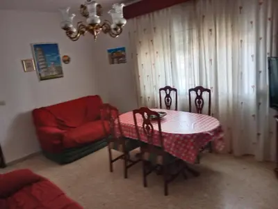 a dining room with a table and chairs and a couch at La Casa de la Abuela Jesús in Sanlúcar de Barrameda