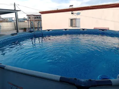 a large pool of blue water in front of a building at La Casa de la Abuela Jesús in Sanlúcar de Barrameda
