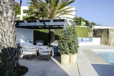 a patio with a table and chairs next to a pool at Casa Vista Azul in El Puerto de Santa María