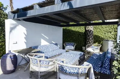 a patio with blue and white chairs and a table at Casa Vista Azul in El Puerto de Santa María