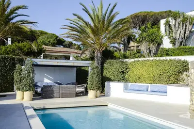 a villa with a swimming pool and palm trees at Casa Vista Azul in El Puerto de Santa María