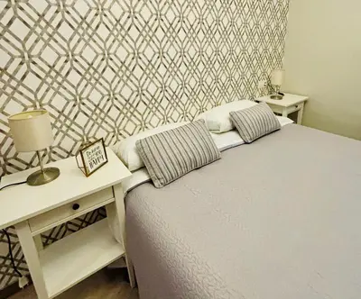 a bedroom with a bed and a table with a night stand at Apartamento FEDUCHY 10 min de la playa 2 baños in Cádiz