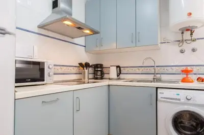 a kitchen with white cabinets and a washing machine at Apartamento FEDUCHY 10 min de la playa 2 baños in Cádiz