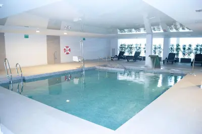 a large swimming pool with blue water in a building at Garbí Costa Luz in Conil de la Frontera