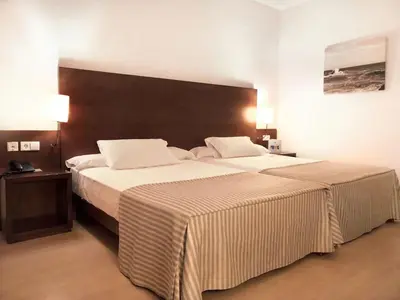 a bedroom with a large bed with a large headboard at Garbí Costa Luz in Conil de la Frontera