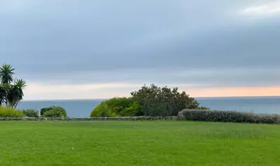 a field of grass with the ocean in the background at Casa Sol de Mar in El Puerto de Santa María