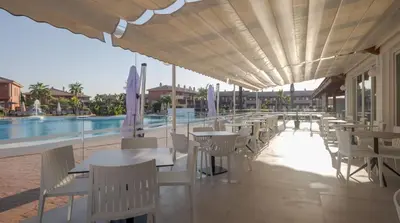 a patio with tables and chairs and a pool at Ilunion Sancti Petri in Chiclana de la Frontera