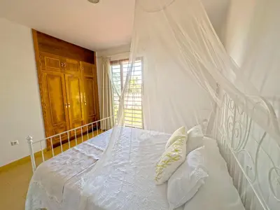 a bedroom with a white bed with a canopy at Villa Los Pinares de Monaco en Roche, Conil, Cádiz in Conil de la Frontera