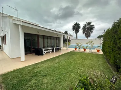 a backyard of a house with a lawn at Villa Los Pinares de Monaco en Roche, Conil, Cádiz in Conil de la Frontera