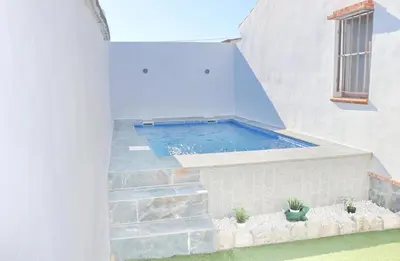 a plunge pool in a white house with plants at Chalet La Higuerita in Conil de la Frontera