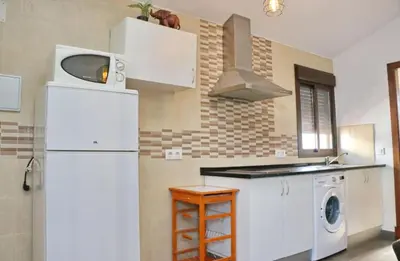 a kitchen with a white refrigerator and a washing machine at Chalet La Higuerita in Conil de la Frontera