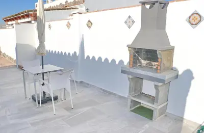 a fireplace in a room with a table and a chair at Chalet La Higuerita in Conil de la Frontera