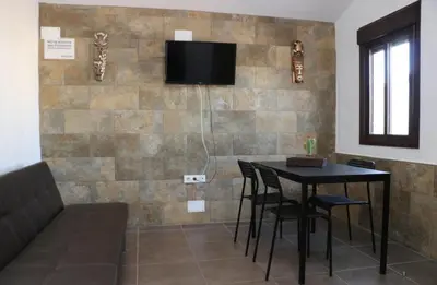 a room with a table and a tv on a wall at Chalet La Higuerita in Conil de la Frontera