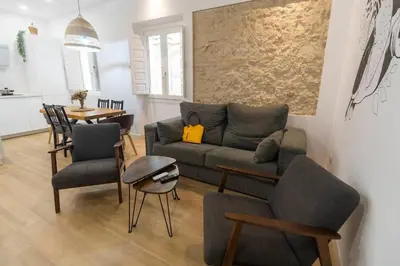 a living room with a couch and chairs and a table at Apartamentos La Cruz Verde in Cádiz