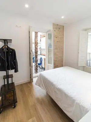 a bedroom with a large white bed and a window at Apartamentos La Cruz Verde in Cádiz
