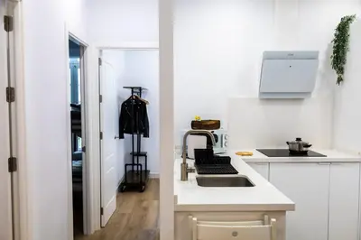 a white kitchen with a sink and a stove at Apartamentos La Cruz Verde in Cádiz