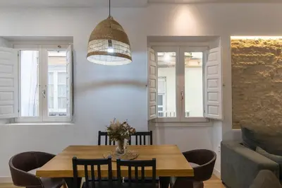a dining room with a table and a couch at Apartamentos La Cruz Verde in Cádiz